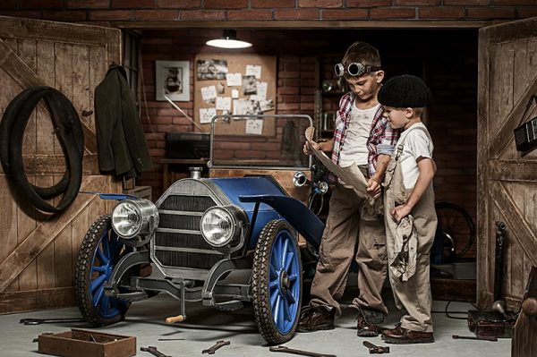 Children building and repairing small blue vintage car - auto mechanic fort mcmurray